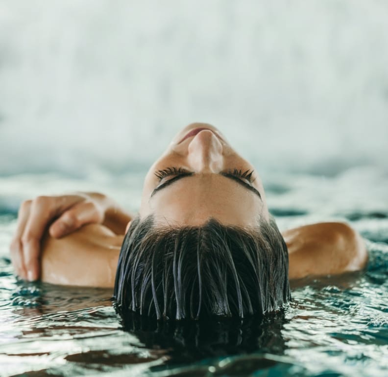 A woman takes a moment to unwind in the pool, one of the many amenities at The Ritz-Carlton Residences, Estero Bay